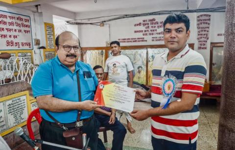 The participation certificate is being presented to a donor